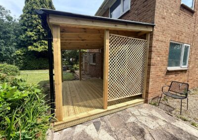 A pergola with wooden decking inside
